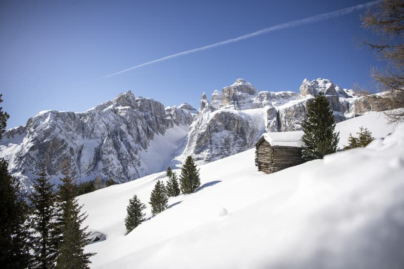 Snowy mountain landscape in Alta Badia with wooden hut and mountains